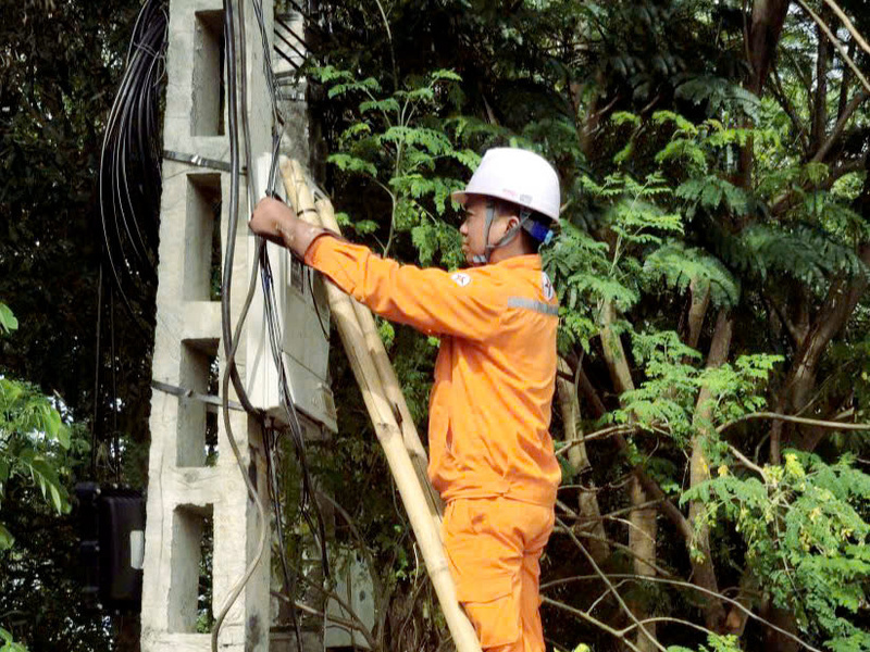 Công nhân Đội quản lý điện khu vực Nghi Sơn kiểm tra, xử lý rò rỉ điện tại dây ra sau công tơ - tài sản của khách hàng. Ảnh: Hùng Mạnh
