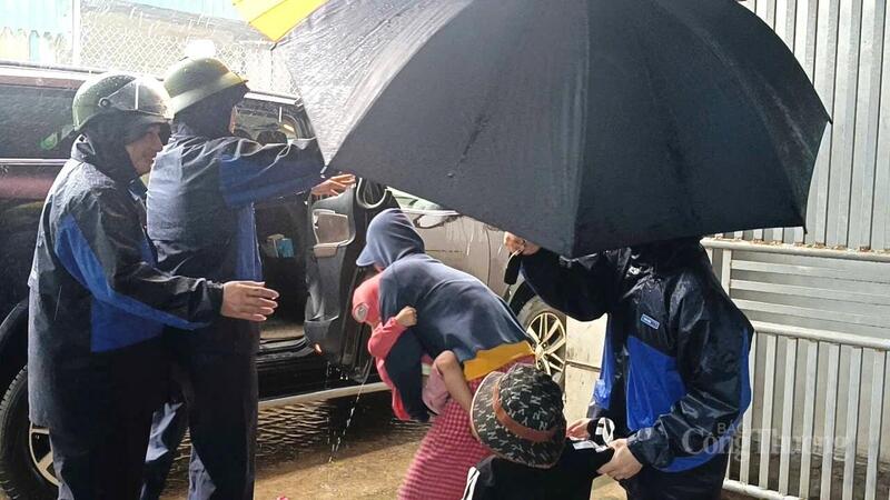 Hỗ trợ người dân lên xe ô tô, di chuyển khỏi khu vực nguy hiểm