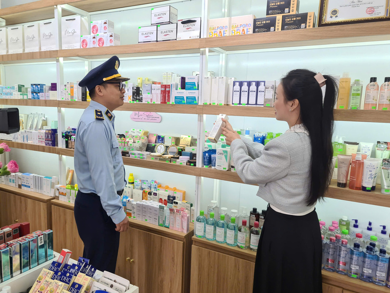 Cán bộ Đội Quản lý thị trường số 10 tuyên truyền đến các hộ kinh doanh tại tuyến phố nói không với hàng giả về chế tài xử lý khi buôn bán hàng giả, hàng không rõ nguồn gốc xuất xứ