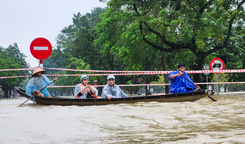 Người dân di chuyển bằng thuyền qua những tuyến đường ngập sâu.