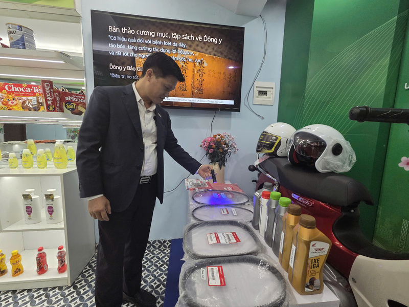 Ông Bùi Văn Định - Trưởng phòng Thực thi Sở hữu trí tuệ của Honda Việt Nam hứng dẫn người tiêu dùng nhìn ra logo HONDA in chìm phản quang dưới ánh sáng của đèn UV. Ảnh: Văn Thi.