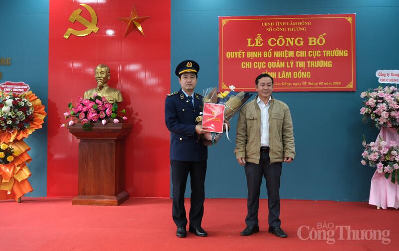 Ông Biện Tấn Tài (bìa phải), Phó Giám đốc Sở Công Thương tỉnh Lâm Đồng tặng hoa và trao quyết định bổ nhiệm Chi cục trưởng Chi cục Quản lý thị trường tỉnh Lâm Đồng cho ông Phan Văn Tuyên. Ảnh: Lê Sơn