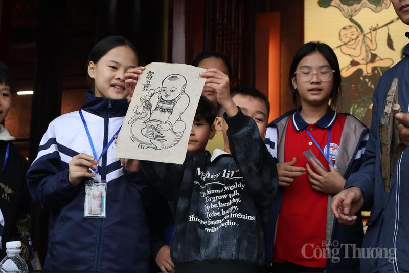 Các bạn trẻ hào hứng hoàn thiện tác phẩm, trực tiếp cầm trên tay những tờ tranh Đông Hồ tươi màu mực in.