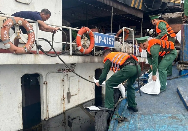 Cán bộ, chiến sĩ Ban Chỉ huy Biên phòng Cửa khẩu cảng Nghi Sơn thả vật liệu thấm dầu, khẩn trương xử lý sự cố tràn dầu sau vụ chìm tàu tại Cảng Quốc tế Long Sơn. Ảnh: Bộ đội Biên phòng tỉnh Thanh Hóa