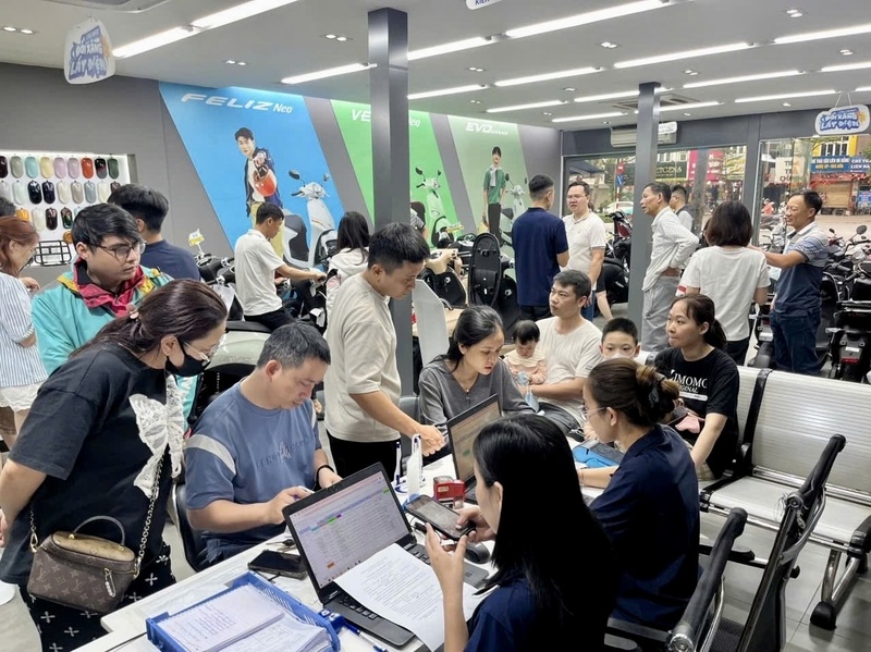 Người dân đến cửa hàng xe điện tìm hiểu, mua xe điện mới và tham gia chương trình định giá miễn phí xe xăng cũ. Ảnh: Huy Hiệu