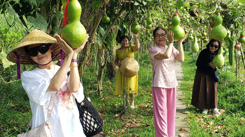 Du khách trải nghiệm du lịch miệt vườn, chụp ảnh và tham quan vườn trái cây trong không gian vườn quê xanh mát. Ảnh: Minh Anh.
