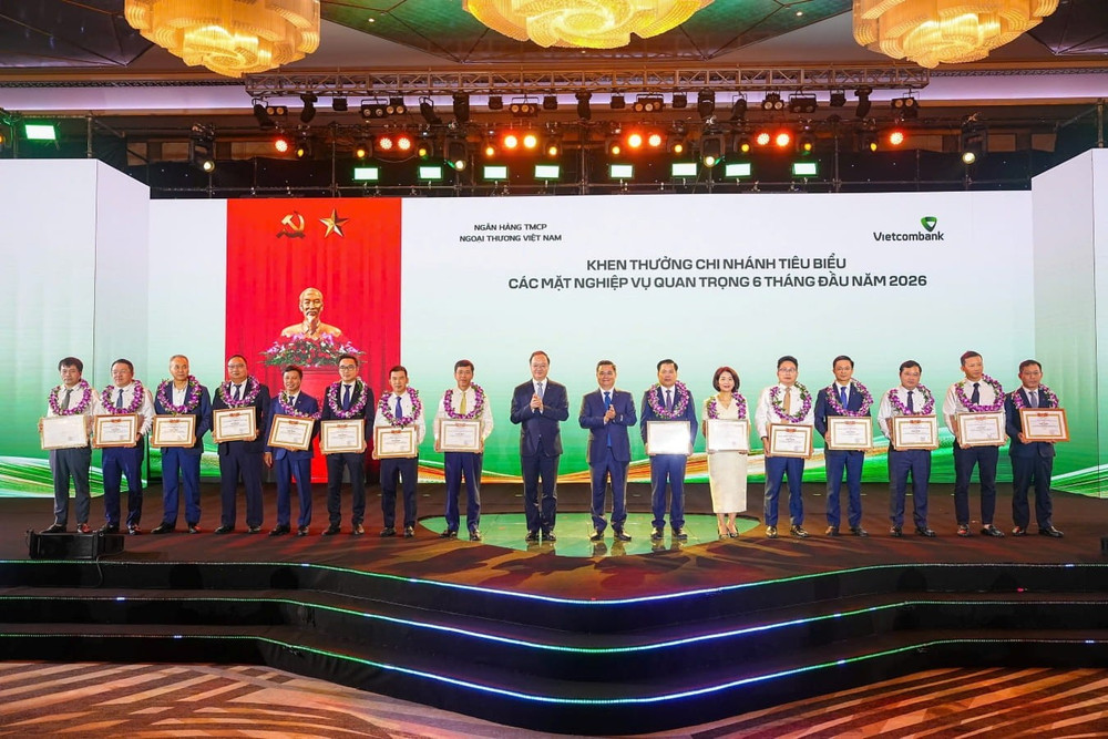 Ông Nguyễn Thanh Tùng - Bí thư Đảng ủy, Chủ tịch HĐQT Vietcombank (thứ 8 từ phải sang) tặng giấy khen và đ/c Lê Quang Vinh - Phó Bí thư Đảng ủy, Thành viên HĐQT, Tổng Giám đốc Vietcombank (thứ 9 từ phải sang) trao hoa chúc mừng cho 15 chi nhánh tiêu biểu trong hoạt động kinh doanh 6 tháng đầu năm 2026 Ông Nguyễn Thanh Tùng - Bí thư Đảng ủy, Chủ tịch HĐQT Vietcombank (thứ 8 từ phải sang) tặng giấy khen và đ/c Lê Quang Vinh - Phó Bí thư Đảng ủy, Thành viên HĐQT, Tổng Giám đốc Vietcombank (thứ 9 từ phải sang) trao hoa chúc mừng cho 15 chi nhánh tiêu biểu trong hoạt động kinh doanh 6 tháng đầu năm 2026