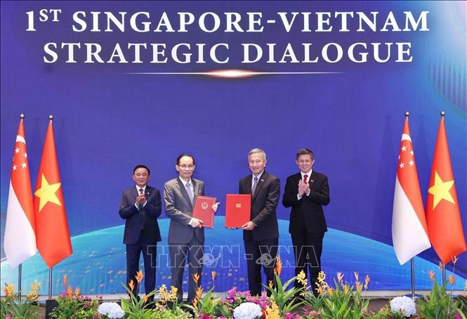 Uỷ viên Bộ Chính trị, Bộ trưởng Ngoại giao Lê Hoài Trung và Bộ trưởng Ngoại giao Singapore Vivian Balakrishnan trao Bản ghi nhớ hợp tác giữa hai Đảng. Ảnh: Phương Hoa /TTXVN 3.jpg