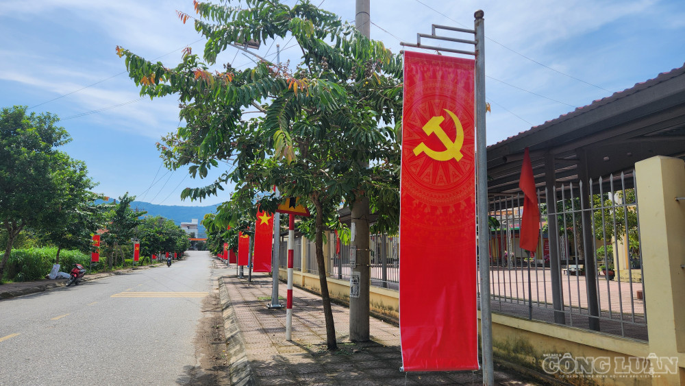 Cờ đỏ được xã Tu Vũ trang trí dọc những trục đường trung tâm xã - Ảnh: Phùng Thọ. clo_br_1000058317.jpg